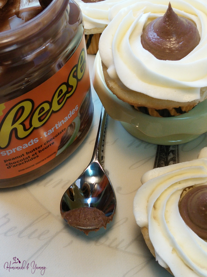 Closeup shot of the top of the Reese's Cupcake, with a jar of Reese chocolate spread on the side.