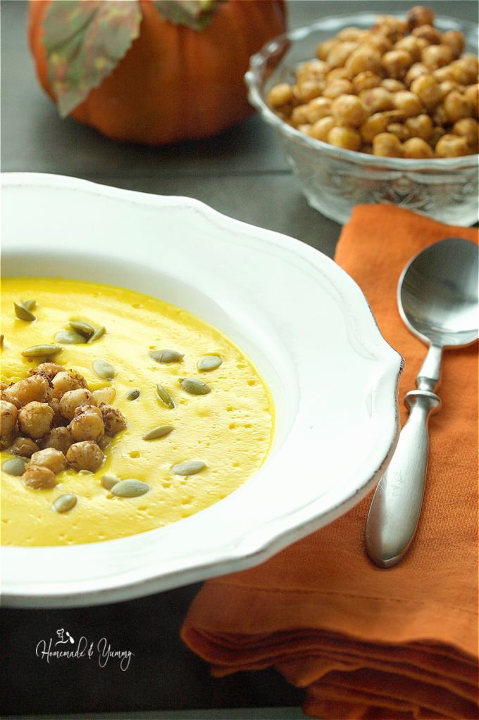 Pumpkin soup in a bowl, garnished with chickpeas, and a bowl of chickpeas in the background.