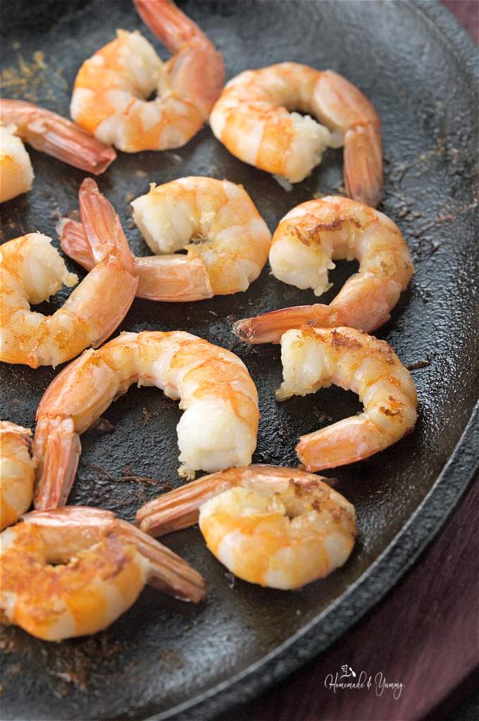 Close up of the cooked shrimps in a cast iron skillet.