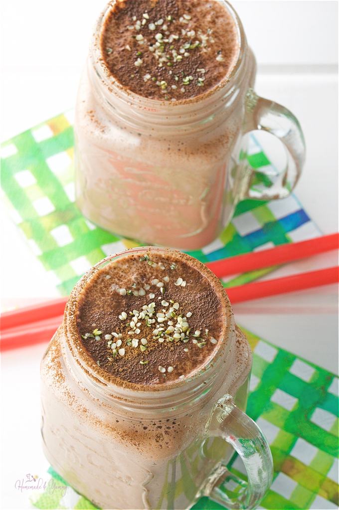Chocolate smoothies in glass mugs sprinkled with cocoa.