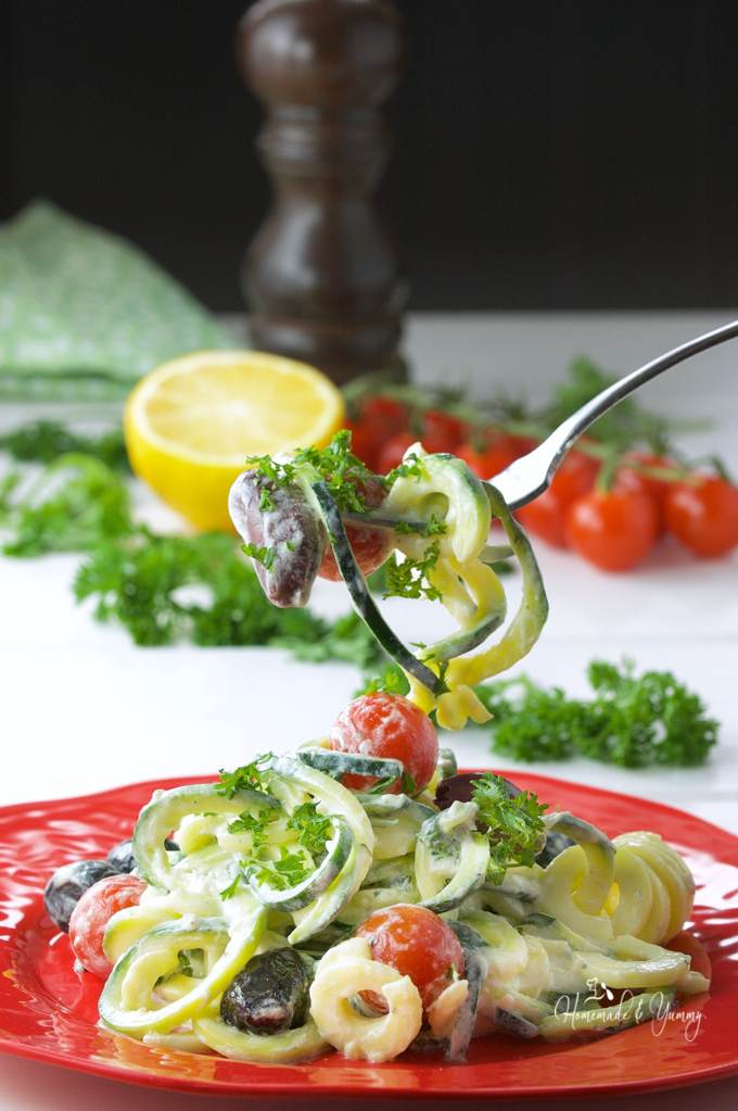 Close up of zoodle salad on a plate with a fork ready to eat.