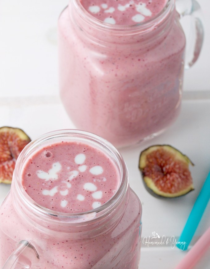 Close up shot of kefir smoothie in a mug with fresh figs in the background.