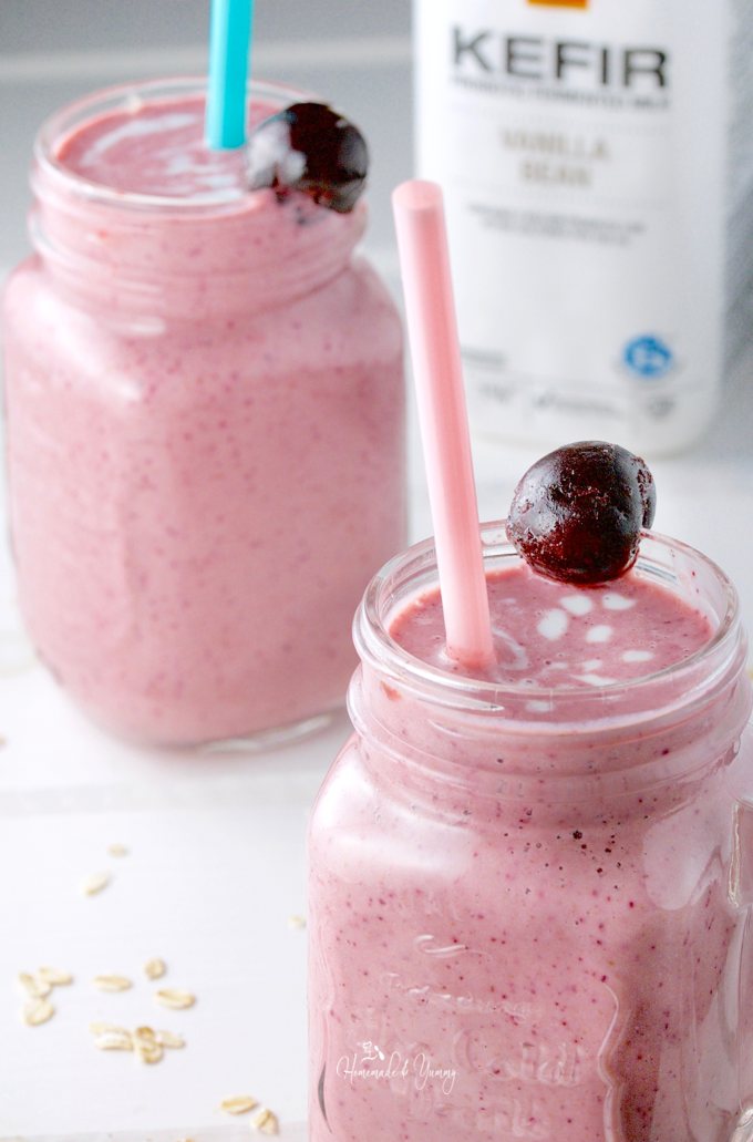 2 smoothies in mugs with a bottle of kefir in the background.