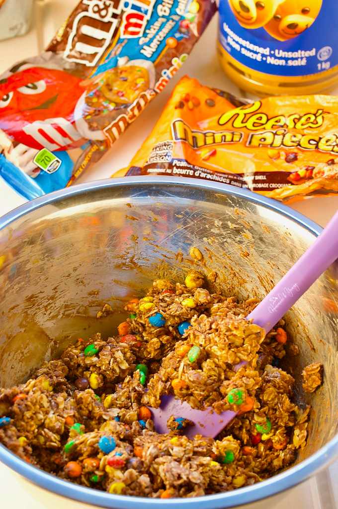 Cookie ingredients getting mixed up in a bowl, with candy packages in the background.