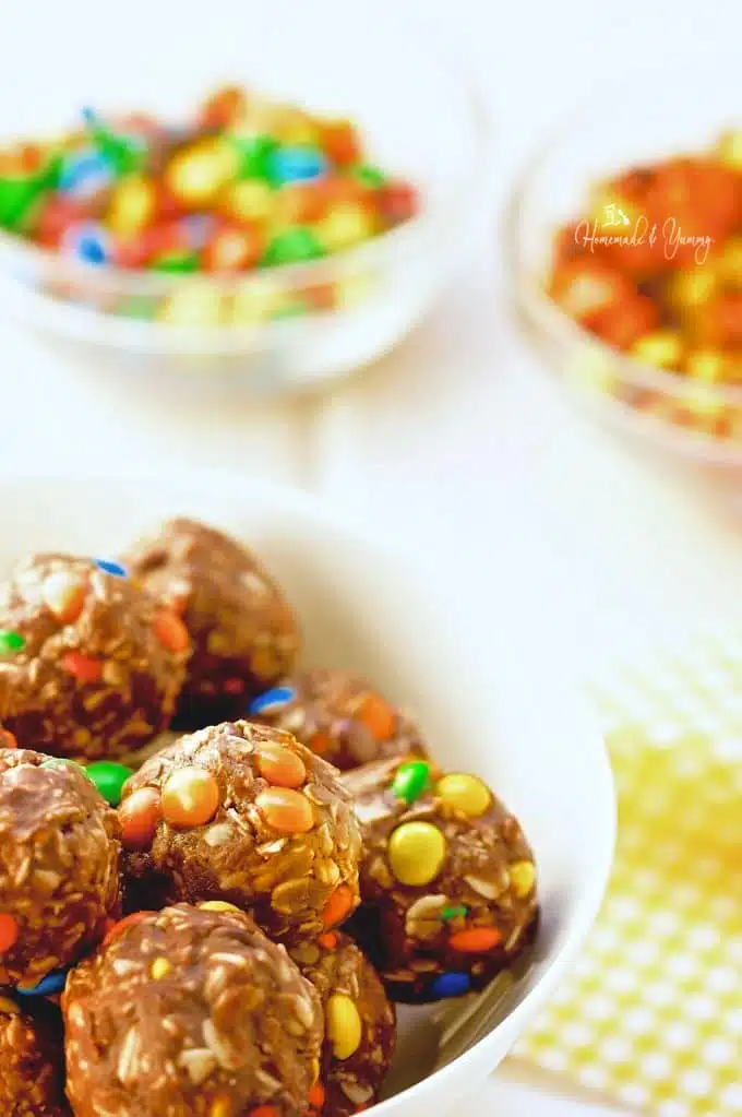  Cookie Balls in a bowl with candies in the background.