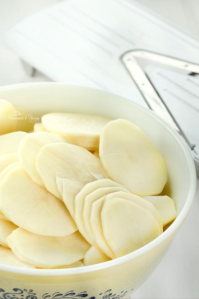 Thin slices of potato in a bowl.