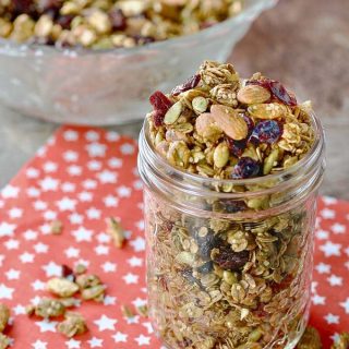Home For the Holidays Festive Crunchy Granola in a glass container ready for gift giving.