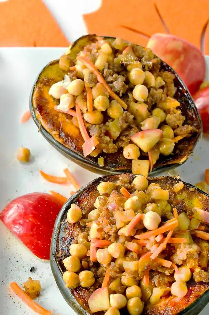 2 baked and stuffed squash halves on a plate.