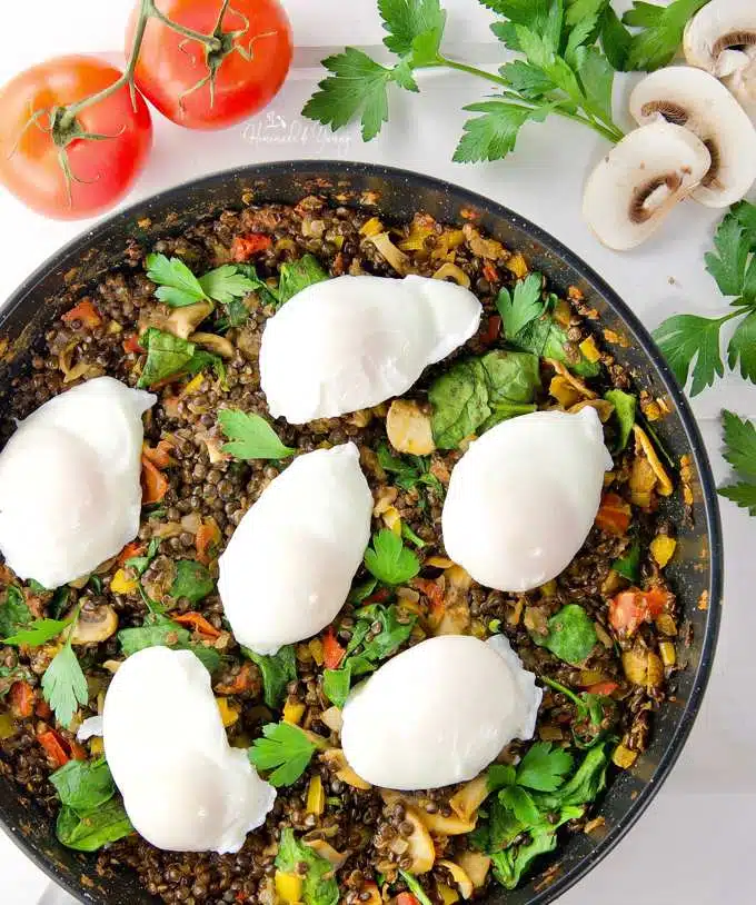 Poached Eggs & Lentil Hash in a pan ready to garnish and serve.