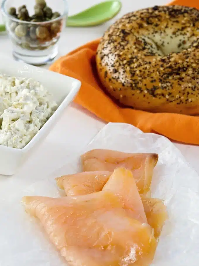 Recipe ingredients, smoked salmon, bagel, cream cheese and capers.