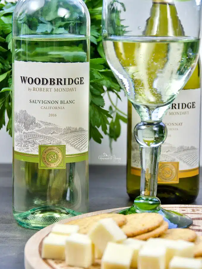 A bottle of Woodbridge by Robert Mondavi wine and board of cheese and crackers.