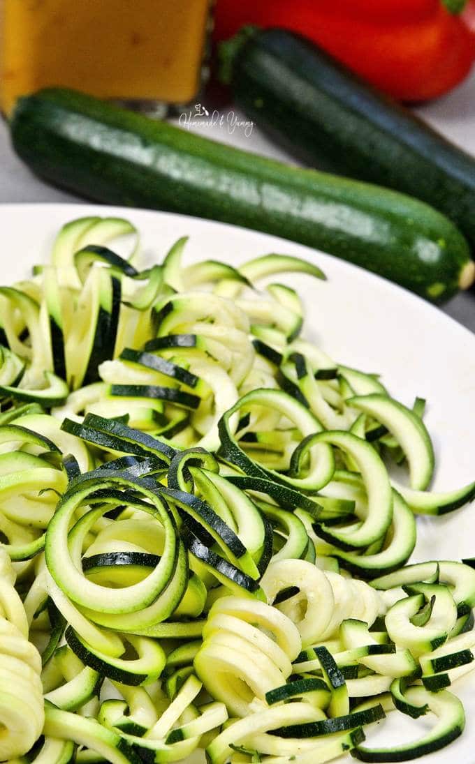 Zucchini noodles on a plate ready to cook.