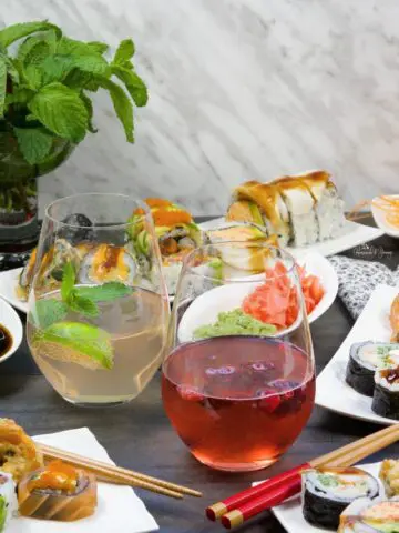 Wine Spritzers on a table with plates of sushi.