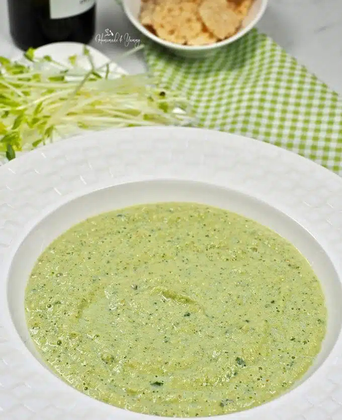 Cold zucchini soup in a white bowl.
