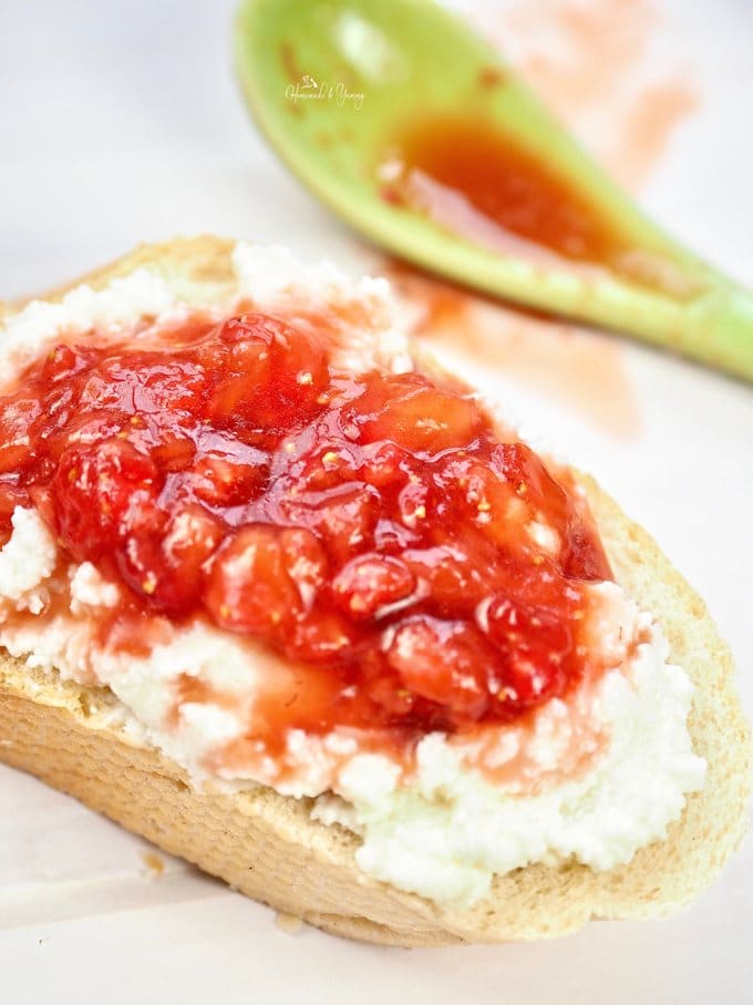 Close up of a slice of bread topped with ricotta and strawberry mixture.