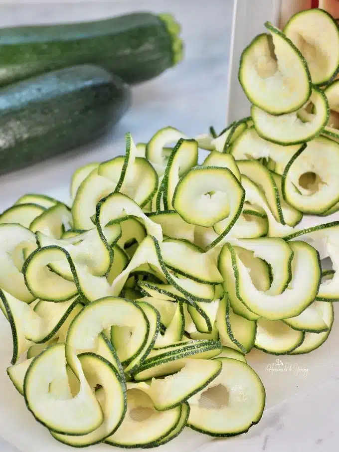 Zucchini getting sliced into ribbons.