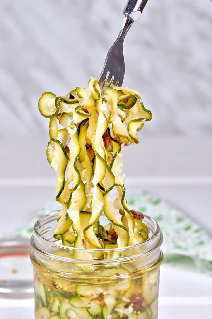 A fork full of refrigerator zucchini pickles .