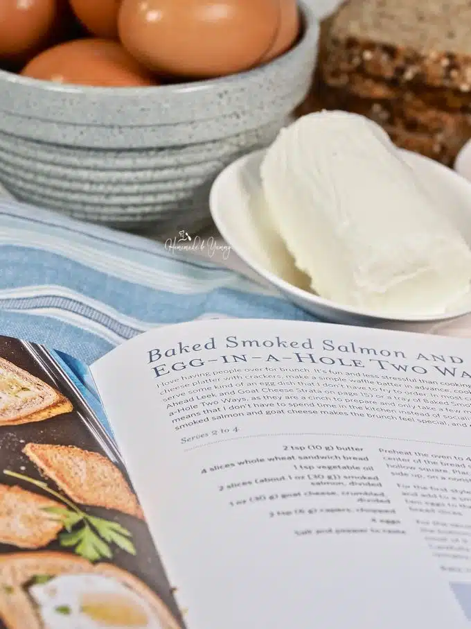 Cookbook opened to the Smoked Salmon Egg In A Hole recipe page.