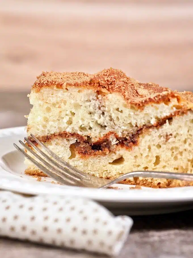 Old fashioned coffee cake on a plate with a fork ready to eat.