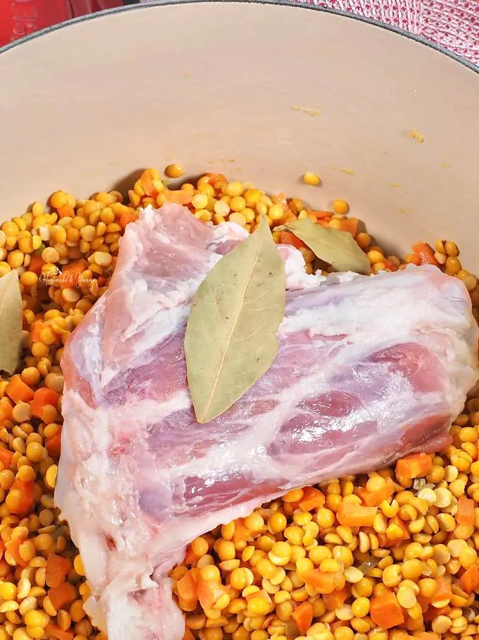 Ham hock, dried peas, carrots and seasonings all part of the ham soup ingredients ready to cook.