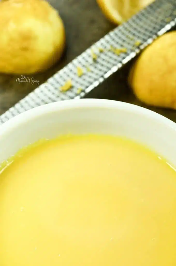 Lemon curd cooked and cooling in a bowl.