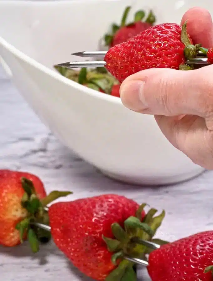 Putting strawberries on a skewer