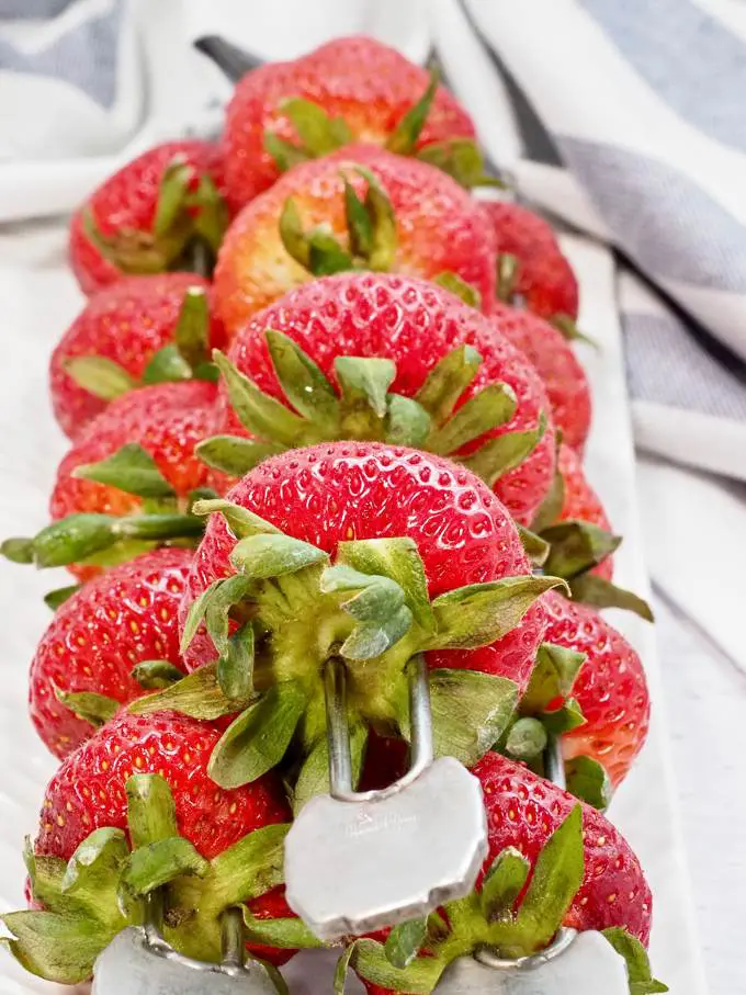A pile of strawberries on skewers ready for the grill.