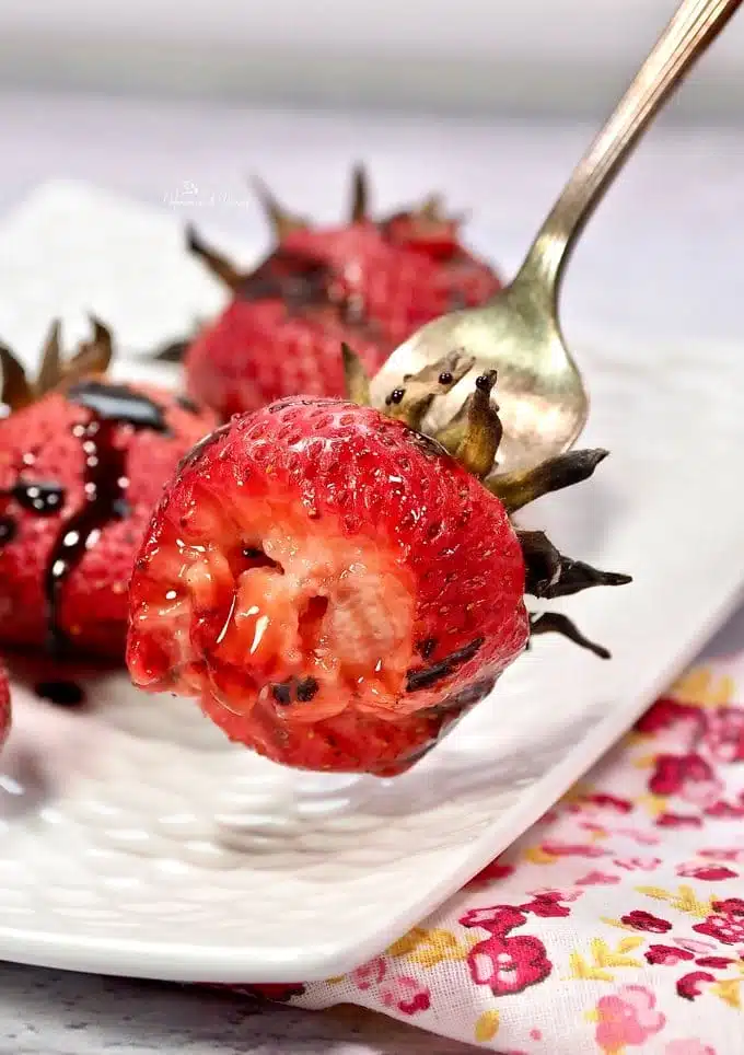 Juicy grilled strawberry on a fork.