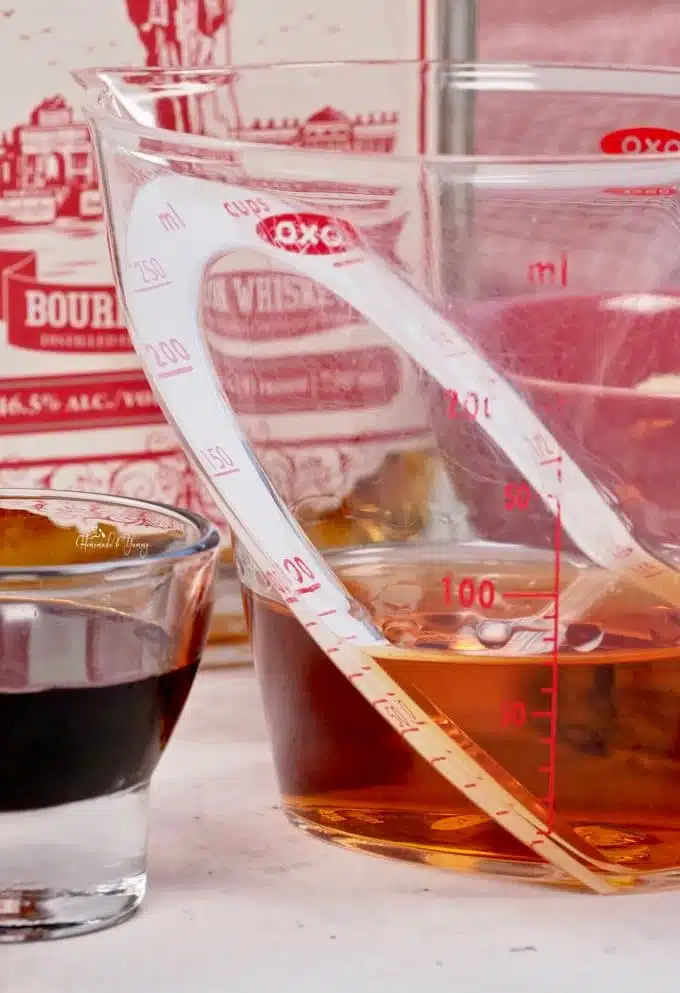 A measuring cup with bourbon in it.