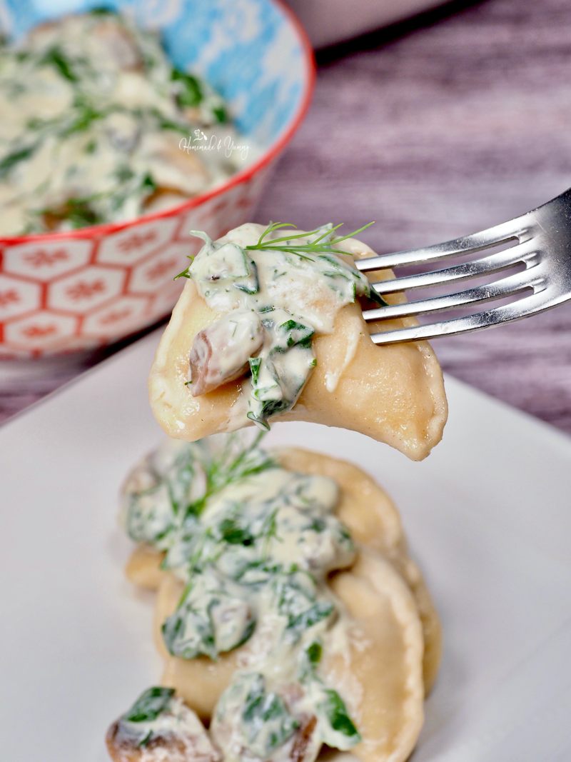 Pierogi on a fork covered in Mushroom Sauce ready to eat.