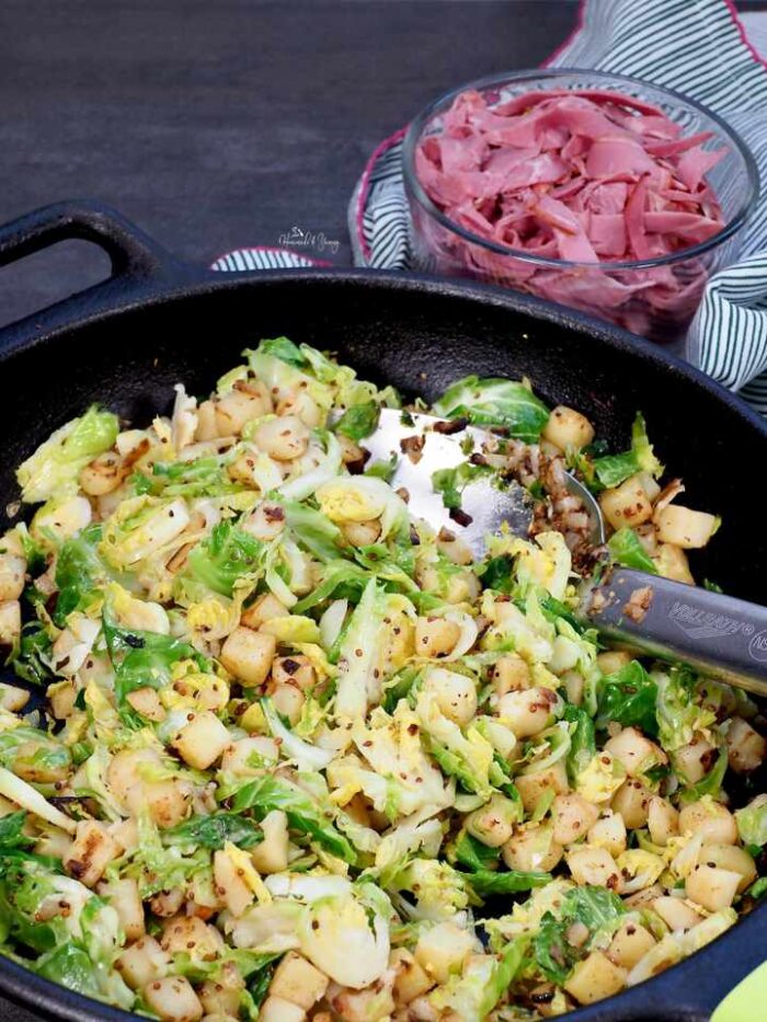 Potatoes and brussels sprouts cooking in a skillet