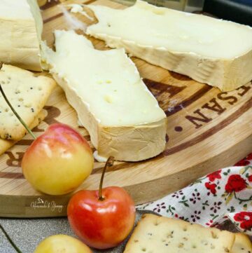 Slices of smoked brie cheese on a wooden board.