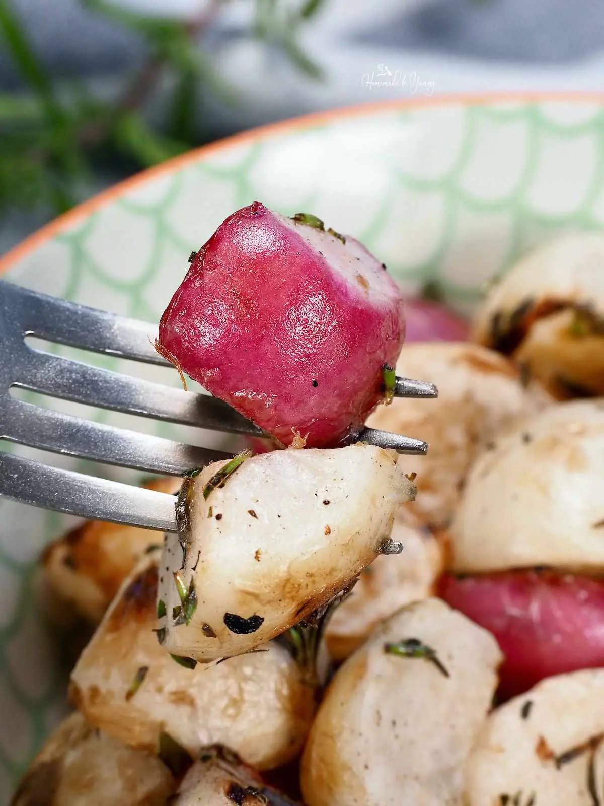 A fork with 1 piece of radish and 1 piece of turnip.