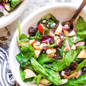 Apple spinach salad in a serving bowl.