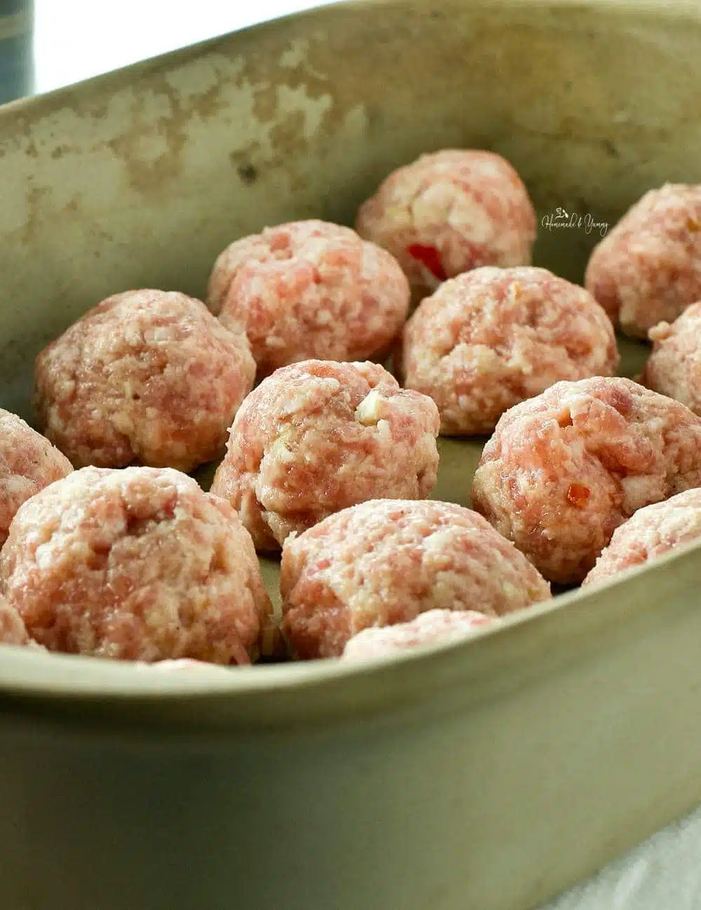 Pork meatballs in a baking dish ready to go into the oven.