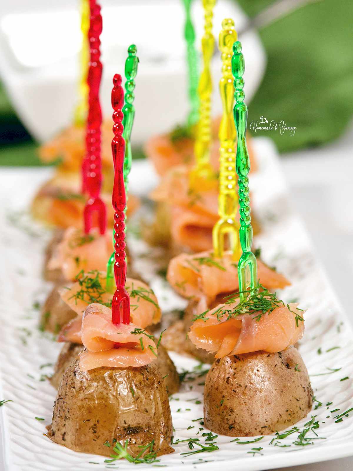 Mini potato skewers topped with smoked salmon on a platter
