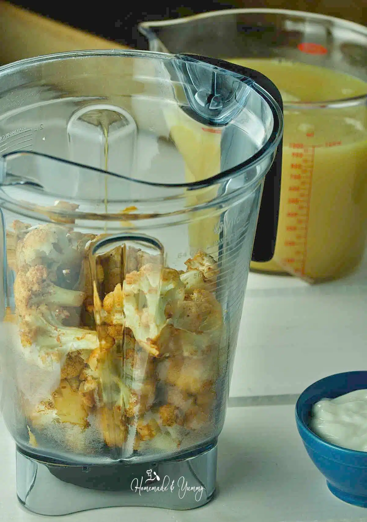 Pieces of roasted cauliflower in a blender.