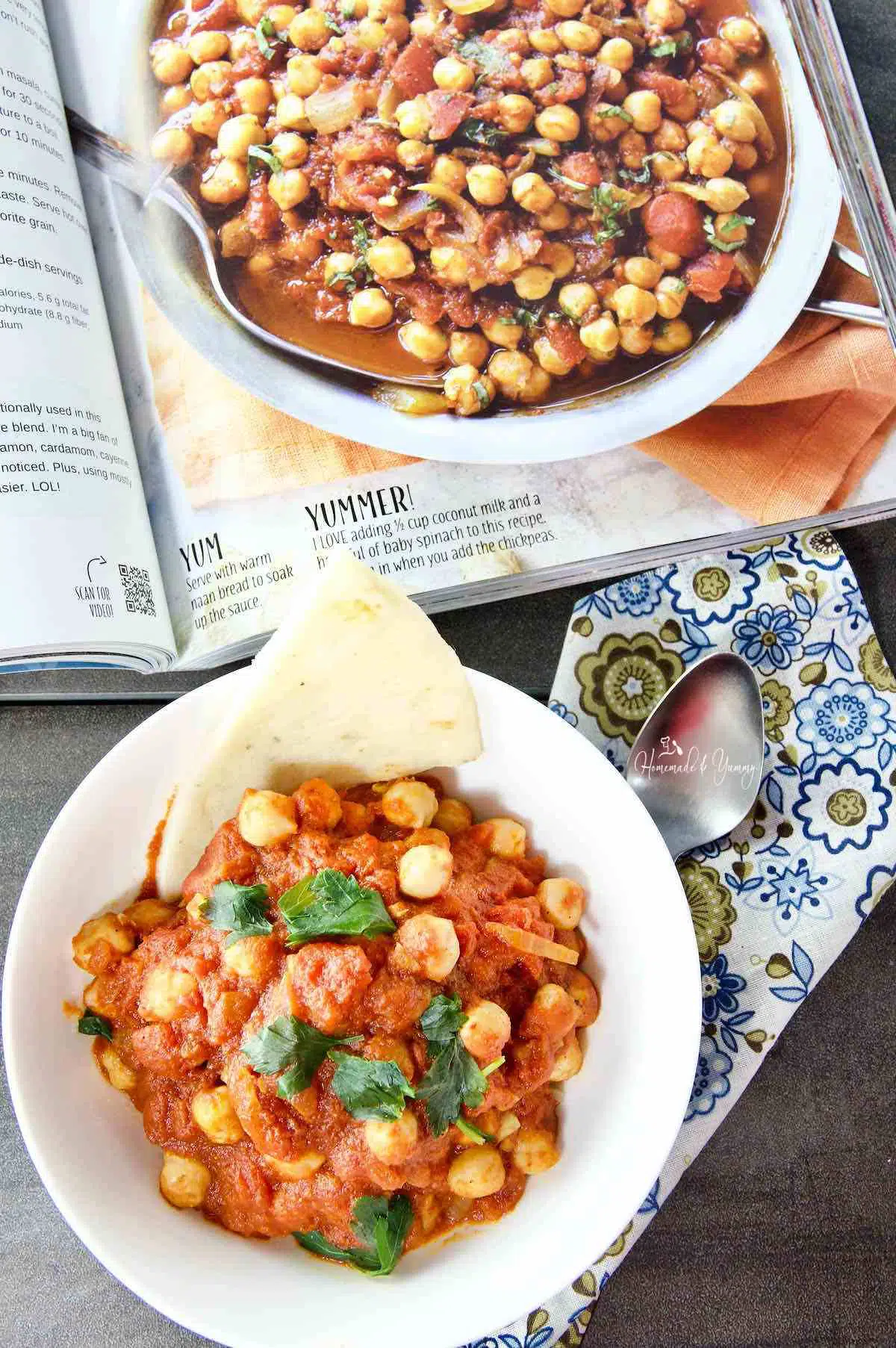 Indian chickpea stew in a bowl, cookbook in the background.