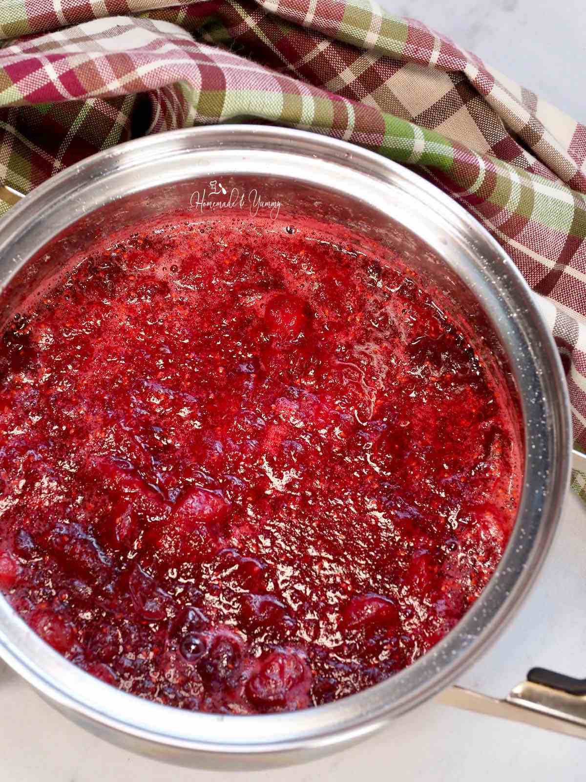 A pot of sauce made from cranberries.