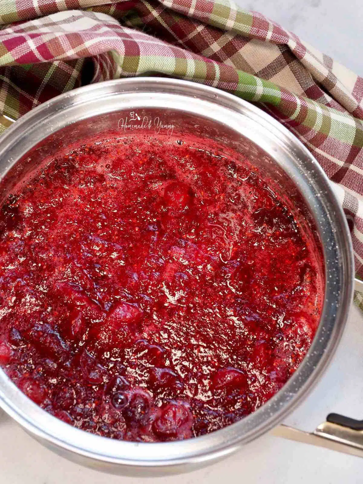 A pot of sauce made from cranberries.