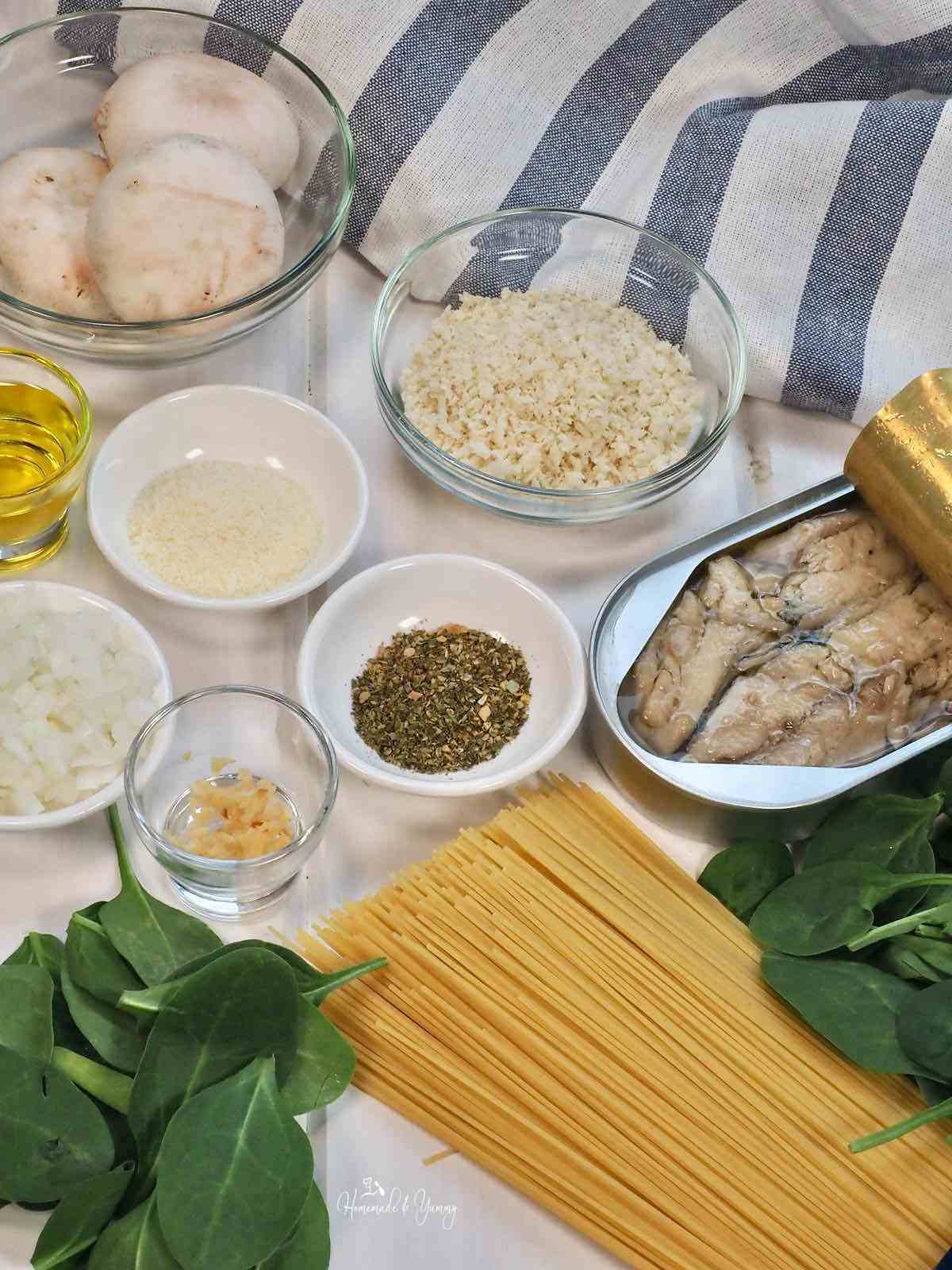 Ingredients to make spaghetti with sardines, mushrooms and spinach.