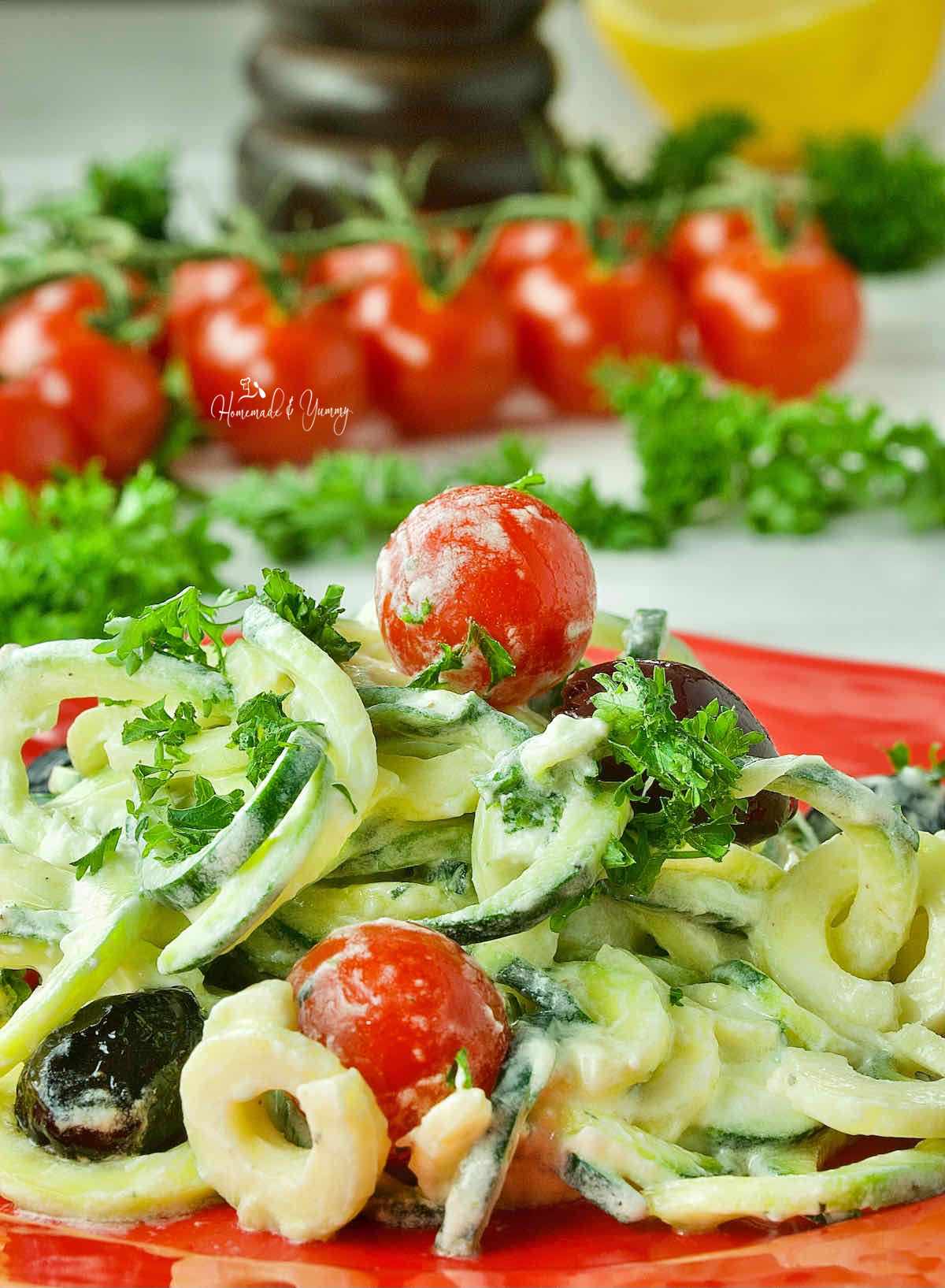 Zucchini noodle salad with olives, tomatoes and creamy goat cheese.