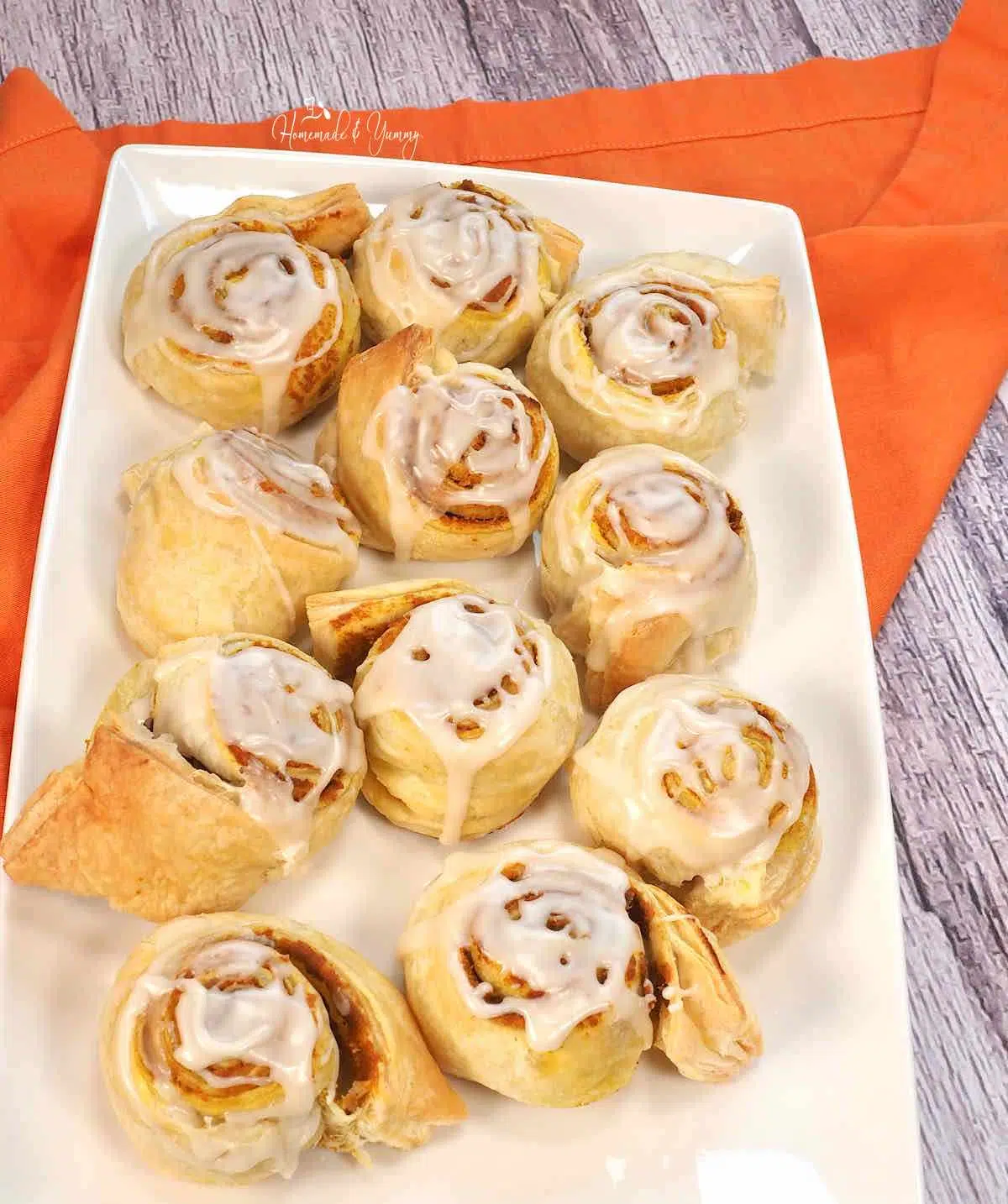 A plate of fresh baked and glazed pumpkin sweet rolls.