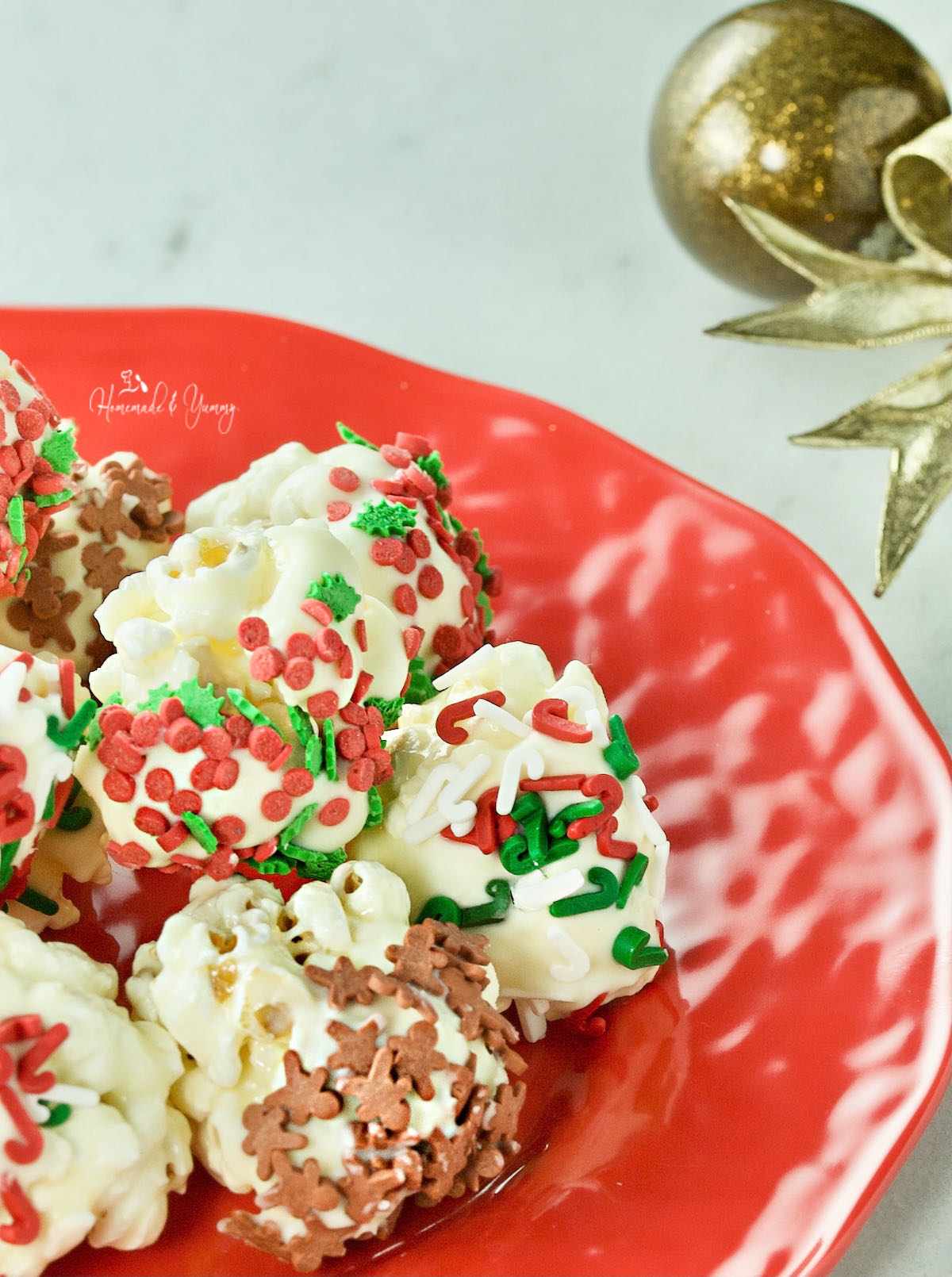 A plate of white chocolate covered popcorn balls for the holidays.