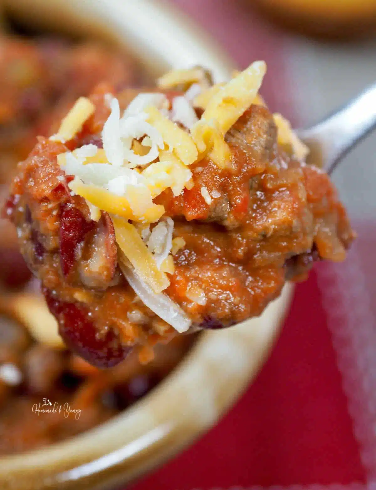 A spoonful of chunky chili make with sirloin steak.