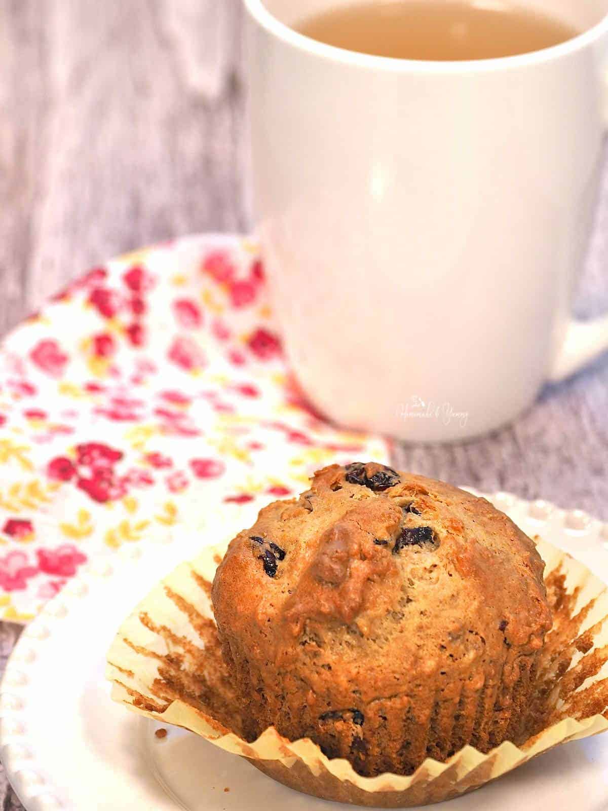 Freshly baked bran flake and cranberry muffin with a cup of tea.