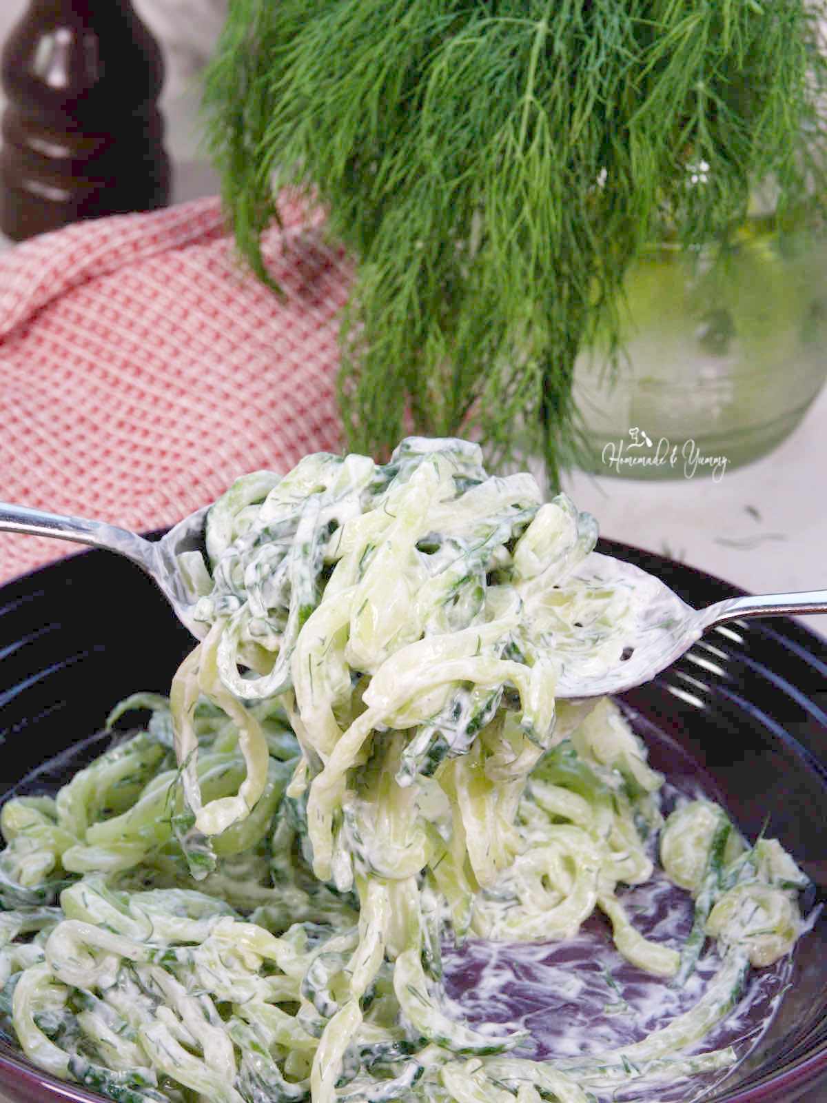 Mixing the dressing on the cucumber noodles.