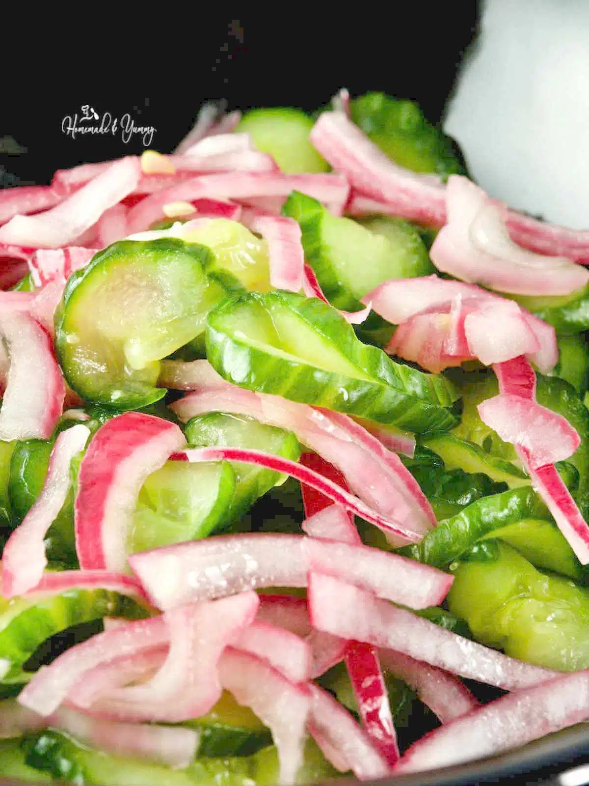 Cucumbers and red onions in a bowl.