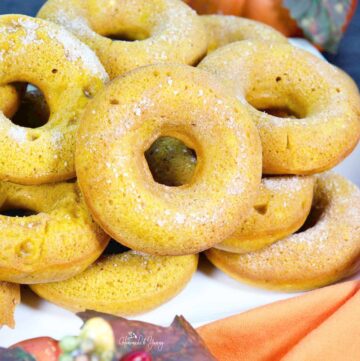Baked pumpkin spice donuts piled on a plate.