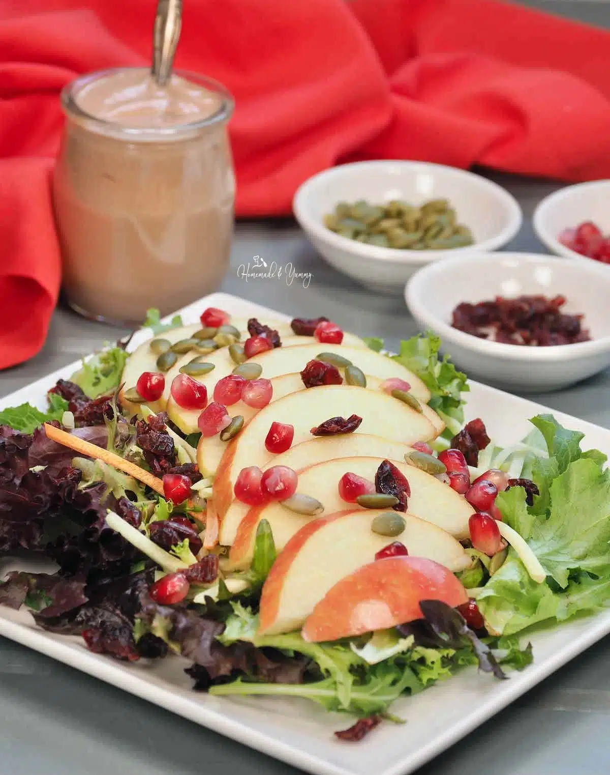 Fall salad with apples, pomegranates, cranberries and pumpkin seeds.